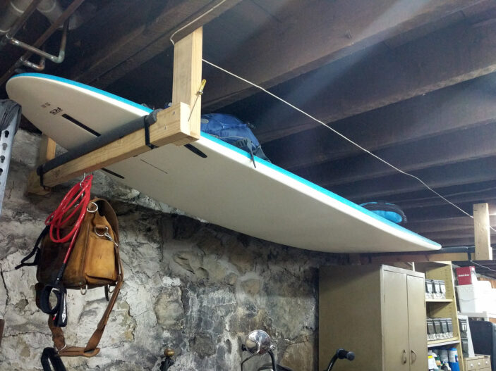 a paddleboard suspended from a basement ceiling